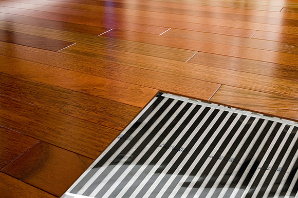 A hardwood floor with a cutaway showing the FilmHeat heating element.
